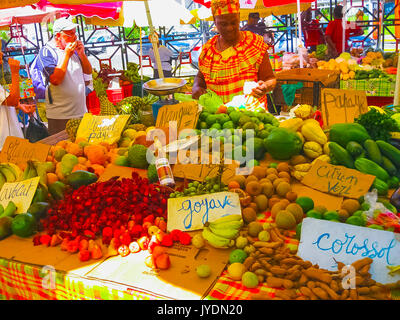 Punto-a-Pitre, Guadalupa - Febbraio 09, 2013: donna vende frutta fresca al mercato all'aperto in Guadalupa. Foto Stock