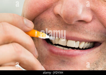 Close-up di un uomo che pulisce i denti Foto Stock