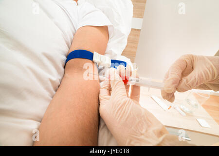 Close-up di medico donna prendendo campioni di sangue del paziente Foto Stock