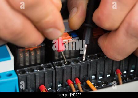 Close-up di un elettricista maschio fusibile di controllo con il multimetro Foto Stock