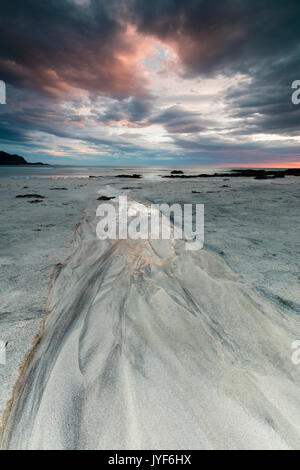 Il sole di mezzanotte e le nuvole cornice alla spiaggia sabbiosa di Flakstad Skagsanden Nordland county Isole Lofoten in Norvegia Europa Foto Stock