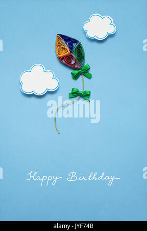 Concetto creativo foto di un aquilone fatto di carta su sfondo blu. Foto Stock