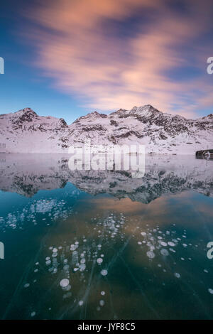 Bolle di ghiaccio e Nuvole rosa telaio congelato il Lago Bianco all'alba del Bernina cantone dei Grigioni Engadina Svizzera Europa Foto Stock