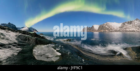 Panorama del mare ghiacciato e picchi rocciosi illuminato dalle luci del nord tungeneset senja Tromso Norvegia europa Foto Stock