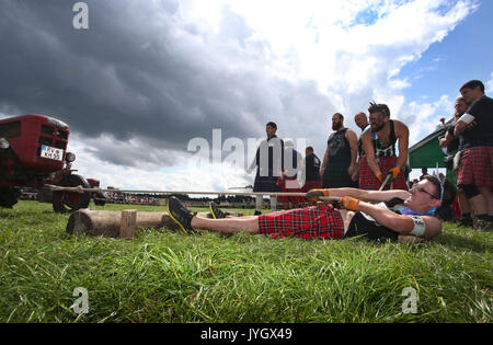 Horgenzell, Germania. 19 Ago, 2017. Un partecipante della tomaia Highlandgames sveva tira un trattore con una corda attraverso un prato nella disciplina "Bulldog-Schleppa' in Horgenzell, Germania, 19 agosto 2017. 15 clan competere gli uni contro gli altri in varie discipline al Highlandgames. Foto: Karl-Josef Hildenbrand/dpa/Alamy Live News Foto Stock