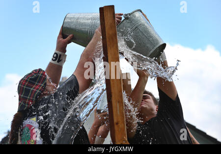 Horgenzell, Germania. 19 Ago, 2017. dpatop - i partecipanti della tomaia Highlandgames sveva di riempire di acqua in un secchio attraverso una barriera nella disciplina "ost-Schöpfa ' in Horgenzell, Germania, 19 agosto 2017. 15 clan competere gli uni contro gli altri in varie discipline al Highlandgames. Foto: Karl-Josef Hildenbrand/dpa/Alamy Live News Foto Stock