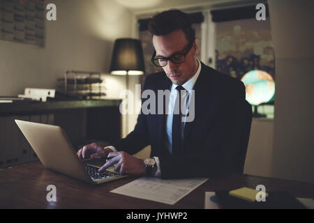 Imprenditore lavorare concentrati su documenti di notte, lavoro straordinario in ufficio Foto Stock