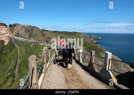 Un cavallo e carrozza con driver tornando a casa dopo una giornata che stava trasportando turisti in giro per l'isola, attraversando la Coupee, una stretta ghiaia causeway Foto Stock