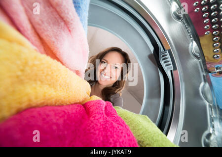 Close-up di donna felice vista dall'interno della rondella con vestiti Foto Stock