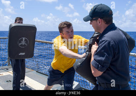 170815-N-ZW825-1207 OCEANO PACIFICO (Agosto 15, 2017) specialista della logistica 2a classe Patrick António, da Fort Worth, Texas, usa un testimone e problemi di comandi verbali di attaccanti simulato a bordo Arleigh Burke-class guidato-missile destroyer USS Sterett (DDG 104) durante una certificazione di sicurezza. Sterett viene distribuito a sostegno della sicurezza marittima e della stabilità nel Indo-Asia-Pacifico ed è operante sotto il comando ed il controllo della U.S. 3a flotta. Stati Uniti 3a flotta operante in avanti offre opzioni aggiuntive per la flotta del Pacifico commander sfruttando le capacità del 3° e 7° flotte. (U.S. Nav Foto Stock