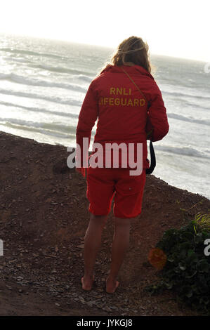 Rnli bagnini a polzeath I'n cornwall sulla spiaggia mantenendo un belvedere per persone in pericolo per salvare vite umane in mare i surfisti in difficoltà a spiagge della Cornovaglia Foto Stock