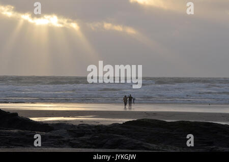 Un paio di amanti sulla spiaggia al tramonto stagliano contro il sole al tramonto romantico immagini atmosferica Foto Stock