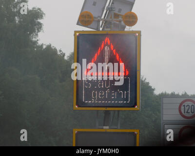 LED Traffic Jam singal: Autostrada Autobahn tedesca autostrada Expressway pericolo di traffico Jam giorno piovoso Foto Stock