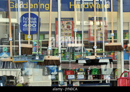 Un giardinaggio e hardware shop finestra che mostra spazzole e scope come pure gli altri componenti hardware per la vendita su high street a St Albans in Cornovaglia Foto Stock