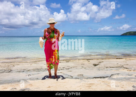 Senior donna holding conch gusci su Dravuni Island Beach, Figi e Sud Pacifico Foto Stock