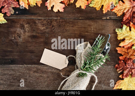 Argenteria e tela igienico con tag oltre rustico sfondo di caduta delle foglie di autunno. Immagine ripresa dalla testa. Foto Stock