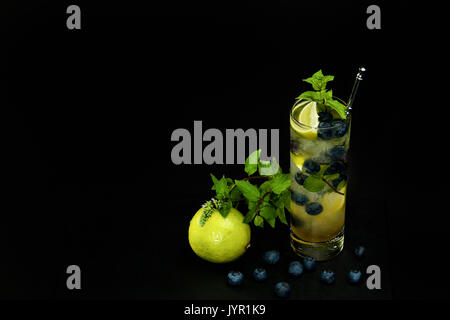 Mirtillo mojito con calce e menta su sfondo nero Foto Stock