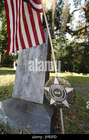 Confederato veterano di guerra evidenziatore lungo con entrambi i flag di confederati e la bandiera americana in un cimitero storico vicino a Ocala, Florida Foto Stock