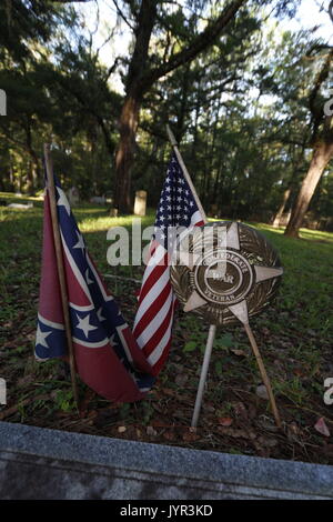 Confederato veterano di guerra evidenziatore lungo con entrambi i flag di confederati e la bandiera americana in un cimitero storico vicino a Ocala, Florida Foto Stock