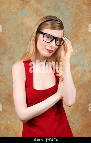 Giovane donna graziosa con gli occhiali in abito rosso Foto Stock