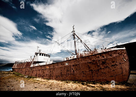 A ovest di fiordi, Islanda. Abbandonate la nave naufragata lungo la costa. Foto Stock