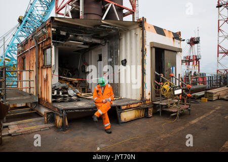 Il petrolio del Mare del nord e il gas lavoratore seduto il riempimento in scartoffie. Credito: lee ramsden / alamy Foto Stock