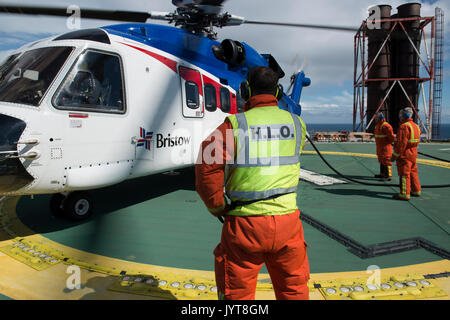 Elicottero bristow, lo sbarco su un mare del Nord il petrolio e il gas piattaforma. helideck team rifornimento, credito: lee ramsden / alamy Foto Stock