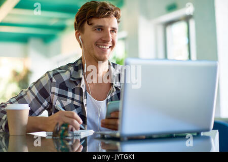 Felice giovane uomo che lavora presso il Creative Office Foto Stock