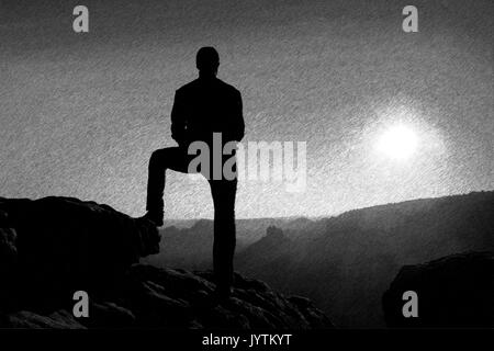 Bianco e Nero tratteggiato schizzo retrò. Un uomo ha le mani sui fianchi. Silhouette sportivo in natura entro l'alba. Foto Stock