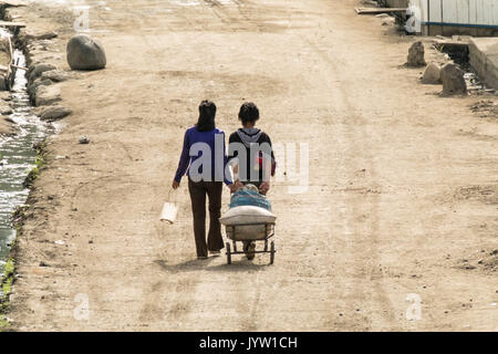 Hyesan, Ryanggang provincia, la Corea del Nord - 6 Agosto 2017: la gente a piedi una strada a un inizio di mattina di sole. Foto Stock