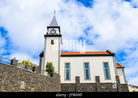 La chiesa edificio contro il cielo blu con nuvole bianche sulla costa dell'isola di Madeira, Portogallo Foto Stock