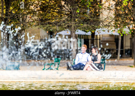 Giovane si siede da fontana nel Jardin du Palais Royal Foto Stock