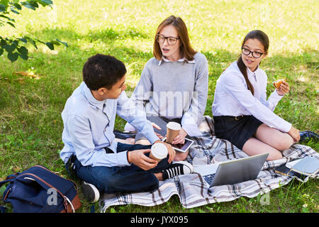 Gli studenti della scuola secondaria avente Picnic Foto Stock