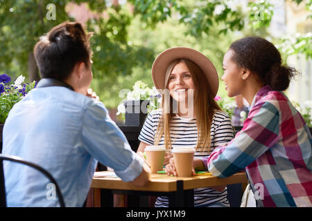Gli studenti in chat a pranzo al Cafe' all'aperto Foto Stock