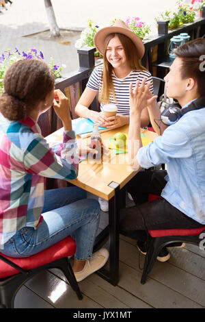 Gli studenti parlando a pranzo in Outdoor Cafe Foto Stock