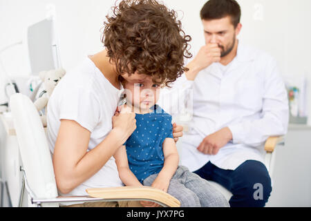 Il pianto Little Boy in ufficio medici Foto Stock