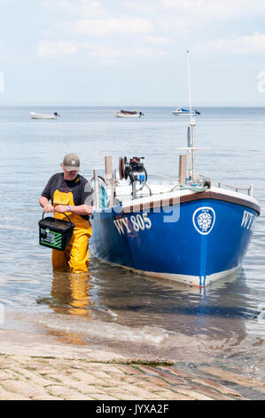 Lobster fisherman sbarcano dalla piccola barca a Robin Hood's Bay nel North Yorkshire. Foto Stock