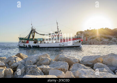 Imbarcazione da diporto con allegro turisti entra nel porto di Makarska, Croazia. Foto Stock