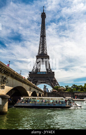 La Torre Eiffel, incorniciata dal fiume Senna e passando per la barca turistica, Foto Stock