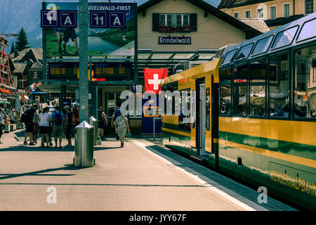 Grindelwald, Oberland bernese, Svizzera - 1 agosto 2017 : giallo - verde treno dall'Wengernalpbahn in Grindelwald stazione ferroviaria Foto Stock