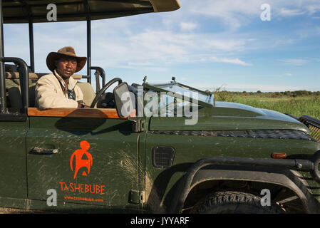 Un autista e guida in un jeep safari, Deserto Kalahari, Kgalagadi Parco transfrontaliero, Botswana Foto Stock