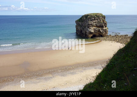 La gente sulla spiaggia a Marsden Rock una formazione rocciosa di calcare fuori del litorale del Mare del Nord a South Shields Inghilterra Foto Stock