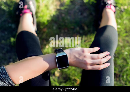 Close-up shot. Donna sportive dopo la sessione di allenamento fitness controllo risultati su Smart Watch. Vista superiore colpo di giovane donna controllo progressi fitness su Foto Stock