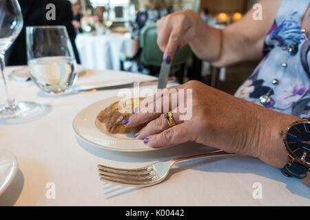 Roux a landau ristorante,l'Hotel Langham, 1C Portland Pl, Marylebone, London, Regno Unito donna pane di taglio stretta di mano. Foto Stock