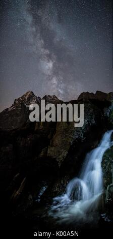 La via lattea su Monviso illumina una piccola cascata. Cozian Alpi, Piemonte, Italia. Europa Foto Stock