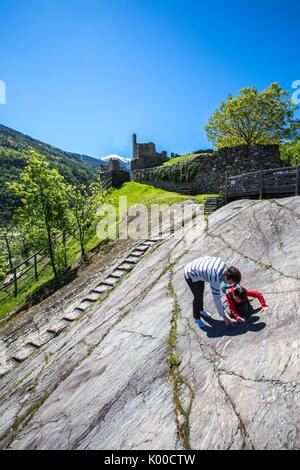 I turisti osservare le incisioni rupestri della Rupe Magna vicino al Castello Visconti Venosta di Grosio. Provincia di Sondrio. La Valtellina. Lombardia. L'Italia. Europa Foto Stock