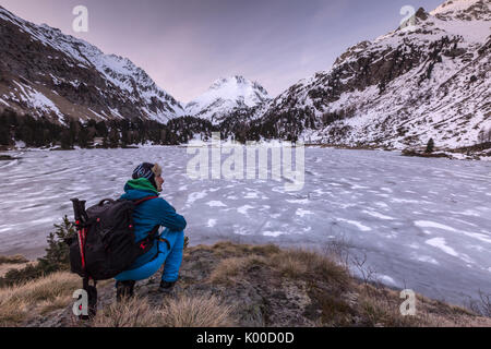 Escursionista ammira Val Bregaglia dal lago Cavloc a sunrise. Svizzera Foto Stock