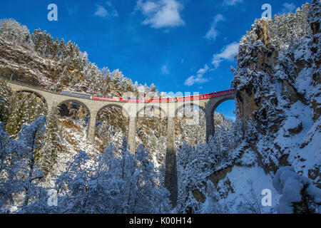 Bernina Express passa attraverso i boschi innevati Filisur Cantone dei Grigioni Svizzera Europa Foto Stock