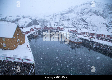 La nevicata sul villaggio di pescatori e il mare ghiacciato Nusfjord Isole Lofoten in Norvegia Europa Foto Stock