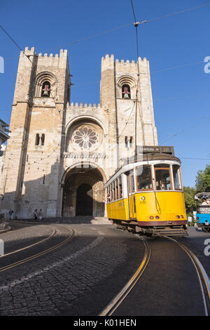 Il giallo il tram numero 28, vicino all'antica cattedrale di quartiere Alfama Lisbona Portogallo Europa Foto Stock
